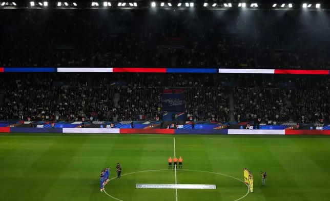 Ukrainian, right, and French players observe a minute of silence in tribute to the victims of the Nov.13, 2015 Paris attacks, ahead of the 2026 World Cup qualifiers Europe zone group D football match between France and Ukraine at the Parc des Princes stadium, Thursday, Nov. 13, 2025 in Paris. ( Franck Fife, Pool photo via AP)