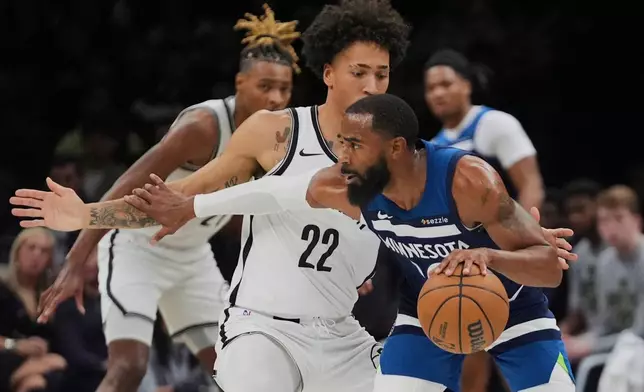 Brooklyn Nets' Jalen Wilson (22) defends Minnesota Timberwolves' Mike Conley (10) during the first half of an NBA basketball game Monday, Nov. 3, 2025, at Barclays Center in New York. (AP Photo/Frank Franklin II)