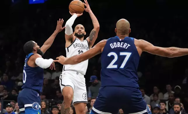 Brooklyn Nets' Tyrese Martin, center, shoots over Minnesota Timberwolves' Mike Conley, left, and Rudy Gobert during the first half of an NBA basketball game Monday, Nov. 3, 2025, at Barclays Center in New York. (AP Photo/Frank Franklin II)