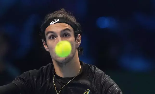 Italy's Lorenzo Musetti returns the ball to United States' Taylor Fritz during their singles tennis match of the ATP World Tour Finals, in Turin, Italy, Monday, Nov. 10, 2025. (AP Photo/Antonio Calanni)