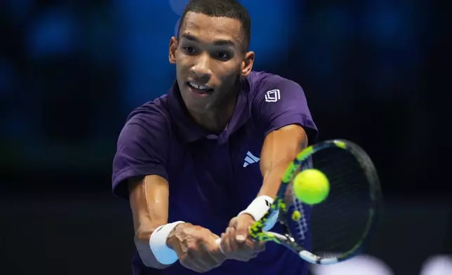Canada's Felix Auger-Aliassime returns the ball to Italy's Jannik Sinner during their tennis match of the ATP World Tour Finals, in Turin, Italy, Monday, Nov. 10, 2025. (AP Photo/Antonio Calanni)