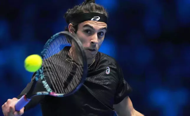 Italy's Lorenzo Musetti returns the ball to United States' Taylor Fritz during their singles tennis match of the ATP World Tour Finals, in Turin, Italy, Monday, Nov. 10, 2025. (AP Photo/Antonio Calanni)