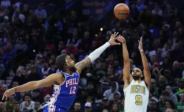 Boston Celtics' Derrick White (9) goes up to shoot against Philadelphia 76ers' Trendon Watford during the first half of an NBA basketball game Tuesday, Nov. 11, 2025, in Philadelphia. (AP Photo/Matt Rourke)