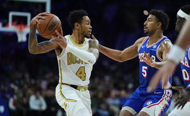 Boston Celtics' Anfernee Simons (4) looks to pass past Philadelphia 76ers' Quentin Grimes during the first half of an NBA basketball game Tuesday, Nov. 11, 2025, in Philadelphia. (AP Photo/Matt Rourke)