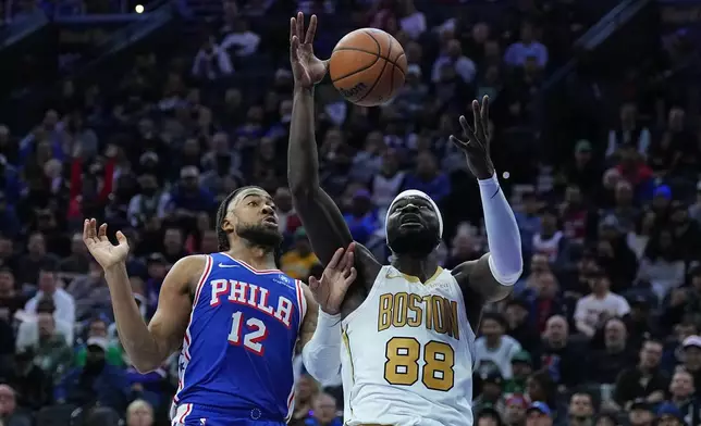 Boston Celtics' Neemias Queta (88) wins the rebound over Philadelphia 76ers' Trendon Watford during the first half of an NBA basketball game Tuesday, Nov. 11, 2025, in Philadelphia. (AP Photo/Matt Rourke)