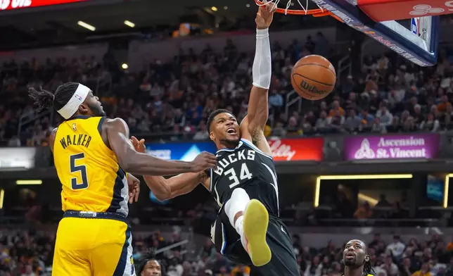 Milwaukee Bucks forward Giannis Antetokounmpo (34) gets a basket on a dunk in front of Indiana Pacers forward Jarace Walker (5) during the first half of an NBA basketball game in Indianapolis, Monday, Nov. 3, 2025. (AP Photo/Michael Conroy)