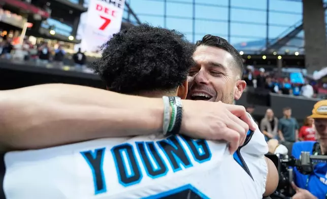 Carolina Panthers head coach Dave Canales, facing, greets quarterback Bryce Young (9) celebrates after an overtime victory over the Atlanta Falcons in an NFL football game, Nov. 16, 2025, in Atlanta. (AP Photo/Brynn Anderson)