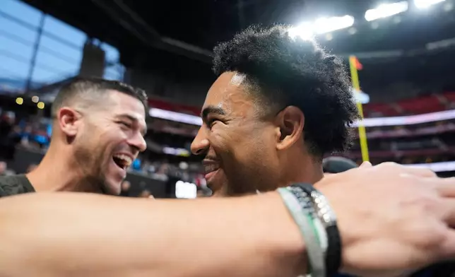 Carolina Panthers head coach Dave Canales, left, greets quarterback Bryce Young (9) celebrates after an overtime victory over the Atlanta Falcons in an NFL football game, Sunday, Nov. 16, 2025, in Atlanta. (AP Photo/Brynn Anderson)