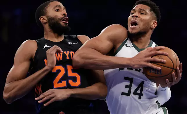 Milwaukee Bucks forward Giannis Antetokounmpo (34) drives past New York Knicks guard Mikal Bridges (25) during the first half of an NBA Cup basketball game Friday, Nov. 28, 2025, in New York. (AP Photo/Adam Hunger)