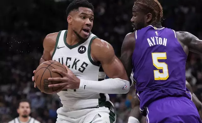 Milwaukee Bucks' Giannis Antetokounmpo tries to get past Los Angeles Lakers' Deandre Ayton during the first half of an NBA basketball game Saturday, Nov. 15, 2025, in Milwaukee. (AP Photo/Morry Gash)