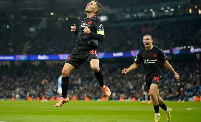 Leverkusen's Alex Grimaldo celebrates after scoring the opening goal of the game during the Champions League opening phase soccer match between Manchester City and Bayer Leverkusen in Manchester, England, Tuesday, Nov. 25, 2025. (AP Photo/Dave Thompson)