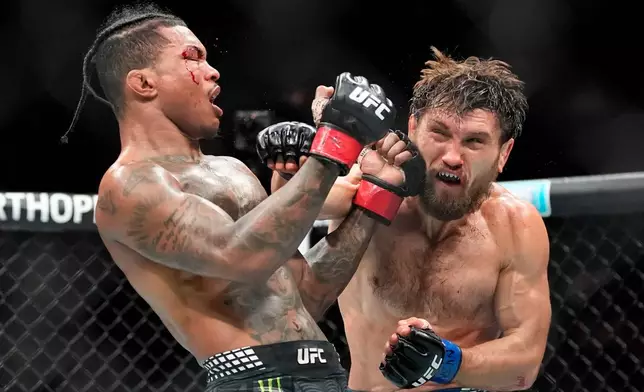 Ethyn Ewing, right, punches Malcolm Wellmaker, left, during the third round of a featherweight bout at the UFC 322 mixed martial arts event, Saturday, Nov. 15, 2025, in New York. (AP Photo/Yuki Iwamura)