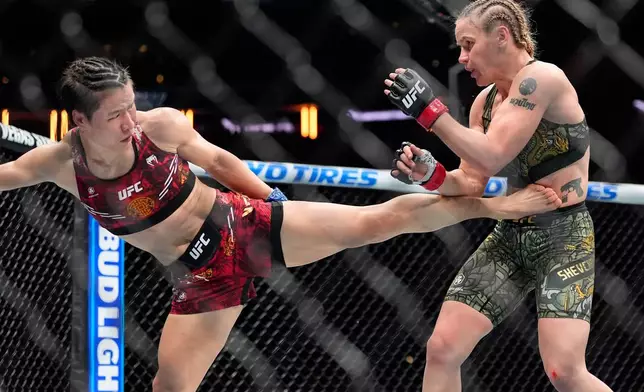 China's Zhang Weili, left, kicks Kyrgyzstan's Valentina Shevchenko, right, during the fourth round of a women's flyweight title bout at the UFC 322 mixed martial arts event, Saturday, Nov. 15, 2025, in New York. (AP Photo/Yuki Iwamura)