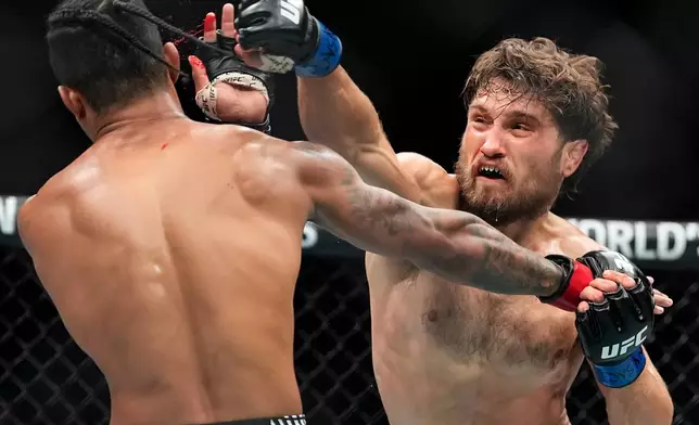 Ethyn Ewing, right, punches Malcolm Wellmaker, left, during the second round of a featherweight bout at the UFC 322 mixed martial arts event, Saturday, Nov. 15, 2025, in New York. (AP Photo/Yuki Iwamura)