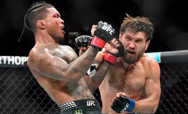 Ethyn Ewing, right, punches Malcolm Wellmaker, left, during the third round of a featherweight bout at the UFC 322 mixed martial arts event, Saturday, Nov. 15, 2025, in New York. (AP Photo/Yuki Iwamura)