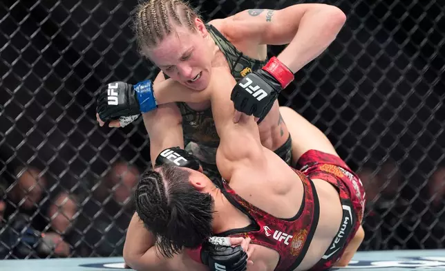 Kyrgyzstan's Valentina Shevchenko, top, grapples with China's Zhang Weili during the fifth round of a women's flyweight title bout at a UFC 322 mixed martial arts event, Saturday, Nov. 15, 2025, in New York. (AP Photo/Yuki Iwamura)