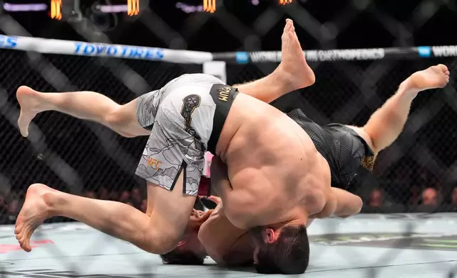 Australia's Jack Della Maddalena grapples with Russia's Islam Makhachev during the first round of a welterweight title bout at the UFC 322 mixed martial arts event, Saturday, Nov. 15, 2025, in New York. (AP Photo/Yuki Iwamura)