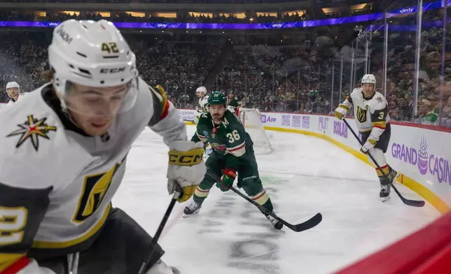 Minnesota Wild player Mats Zuccarello, center, and Vegas Golden Knights players Braeden Bowman, left, and Brayden McNabb chase the puck during the first period of an NHL hockey game, Sunday, Nov. 16, 2025, in St. Paul, Minn. (AP Photo/Lily Dozier)