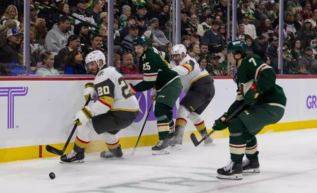 From left, Vegas Golden Knights player Brandon Saad, Minnesota Wild player Jonas Brodin, Golden Knights player Brett Howden and Wild player Brock Faber compete for the puck during the second period of an NHL hockey game, Sunday, Nov. 16, 2025, in St. Paul, Minn. (AP Photo/Lily Dozier)