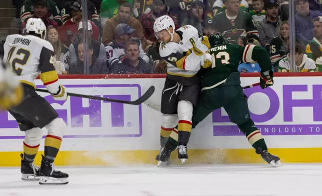 Vegas Golden Knights player Jack Eichel and Minnesota Wild player Yakov Trenin compete for the puck during the second period of an NHL hockey game, Sunday, Nov. 16, 2025, in St. Paul, Minn. (AP Photo/Lily Dozier)