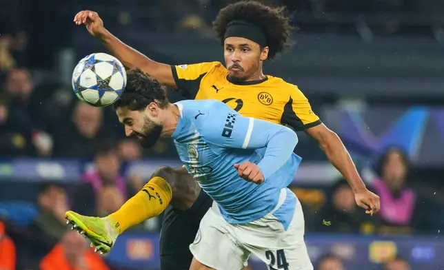 Manchester City's Josko Gvardiol, foreground, and Dortmund's Karim Adeyemi challenge for the ball during the Champions League opening phase soccer match between Manchester City and Borussia Dortmund in Manchester, England, Wednesday, Nov. 5, 2025. (AP Photo/Ian Hodgson)