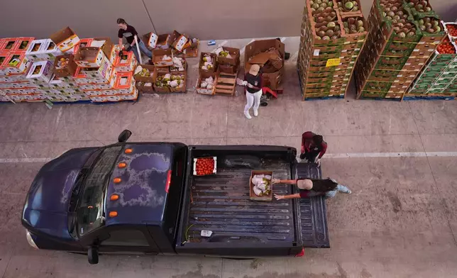 Volunteers help load vehicles during a food distribution at the San Antonio Food Bank for SNAP recipients and other households affected by the federal shutdown, Thursday, Nov. 6, 2025, in San Antonio. (AP Photo/Eric Gay)