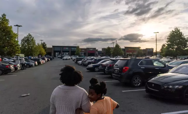 Kiara Alexander, left, who was hospitalized with autoimmune encephalitis, leaves a grocery store with her daughter Kennedi, Friday, Oct. 10, 2025, in Charlotte, N.C. (AP Photo/David Goldman)