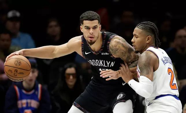 Brooklyn Nets forward Michael Porter Jr. looks to pass around New York Knicks guard Miles McBride (2) during the first half of an NBA basketball game, Monday, Nov. 24, 2025, in New York. (AP Photo/Adam Hunger)