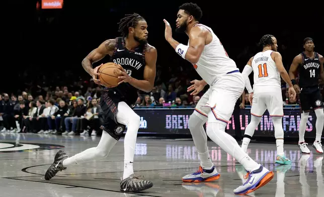 Brooklyn Nets center Nic Claxton drives to the basket past New York Knicks center Karl-Anthony Towns during the second half of an NBA basketball game, Monday, Nov. 24, 2025, in New York. (AP Photo/Adam Hunger)