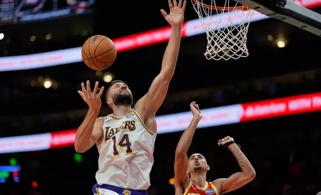 Los Angeles Lakers forward Maxi Kleber (14) shoots against Atlanta Hawks forward Zaccharie Risacher (10) during the second half of an NBA basketball game, Saturday, Nov. 8, 2025, in Atlanta. (AP Photo/Mike Stewart)