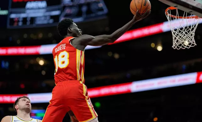 Atlanta Hawks forward Mouhamed Gueye (18) shoots against Los Angeles Lakers guard Luka Doncic (77) during the first half of an NBA basketball game, Saturday, Nov. 8, 2025, in Atlanta. (AP Photo/Mike Stewart)