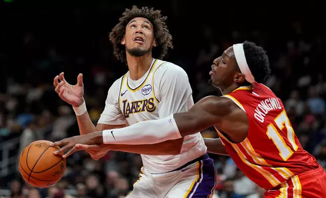 Atlanta Hawks forward Onyeka Okongwu (17) hits the ball against Los Angeles Lakers center Jaxson Hayes (11) during the second half of an NBA basketball game, Saturday, Nov. 8, 2025, in Atlanta. (AP Photo/Mike Stewart)