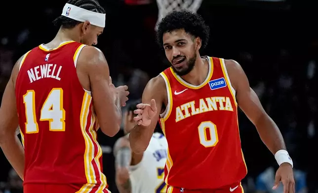 Atlanta Hawks' Jacob Toppin (0) and Asa Newell (14) celebrate a win over the Los Angeles Lakers during the second half of an NBA basketball game, Saturday, Nov. 8, 2025, in Atlanta. (AP Photo/Mike Stewart)