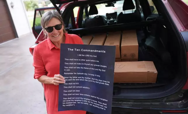 Debbie Leimbach displays one of the hundreds of Ten Commandments posters she was preparing to deliver to local public schools in New Braunfels, Texas, Monday, Nov. 17, 2025. (AP Photo/Eric Gay)