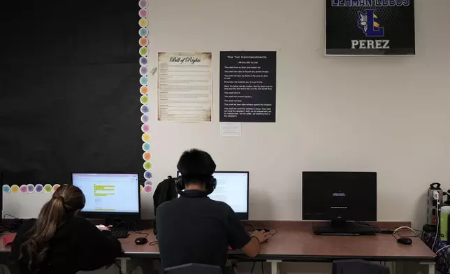 Students work under Ten Commandments and Bill of Rights posters on display in a classroom at Lehman High School, in Kyle, Texas, Thursday, Oct. 16, 2025. (AP Photo/Eric Gay)