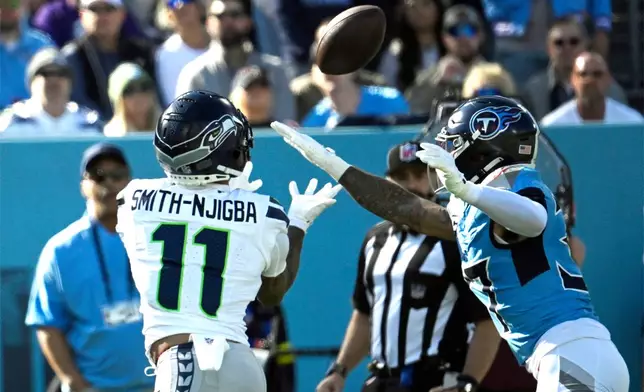 Seattle Seahawks wide receiver Jaxon Smith-Njigba (11) catches a touchdown pass ahead of Tennessee Titans safety Amani Hooker (37) during the first half of an NFL football game Sunday, Nov. 23, 2025, in Nashville, Tenn. (AP Photo/John Amis)