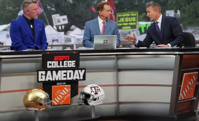 FILE - From left, Pat Mcafee, Nick Saban and Kirk Herbstreit talk on the set of ESPN College Gameday on Saturday, Aug. 31, 2024, in College Station, Texas. (AP Photo/Sam Craft, File)