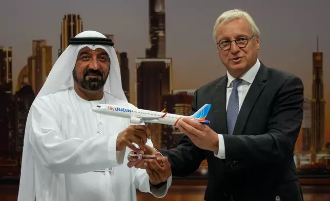 Airbus' CEO of commercial aircraft Christian Scherer presents a model of Airbus A321neo aircraft to Sheikh Ahmed bin Saeed Al Maktoum, the chairman and chief executive of Emirates and chairman of FlyDubai at a press conference to announce an order for 150 Airbus A321neo aircraft at the Dubai Air Show, United Arab Emirates, Tuesday, Nov. 18, 2025. (AP Photo/Altaf Qadri)