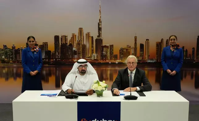 Sheikh Ahmed bin Saeed Al Maktoum, the chairman and chief executive of Emirates and chairman of FlyDubai speaks as Airbus' CEO of commercial aircraft Christian Scherer, right, looks on at a press conference to announce an order for 150 Airbus A321neo aircraft at the Dubai Air Show, United Arab Emirates, Tuesday, Nov. 18, 2025. (AP Photo/Altaf Qadri)
