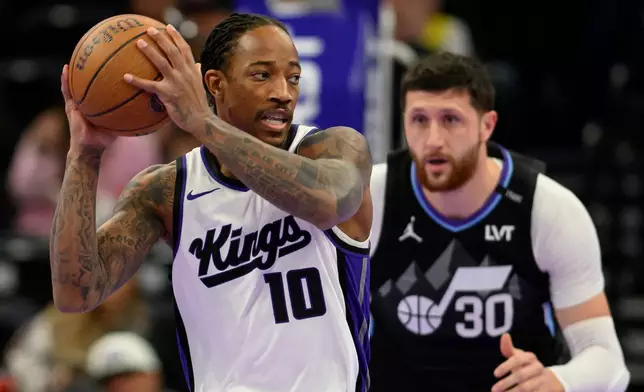 Sacramento Kings guard DeMar DeRozan (10) posts up guarded by Utah Jazz center Jusuf Nurkic (30) during the first half of an NBA Cup basketball game, Friday, Nov. 28, 2025, in Salt Lake City. (AP Photo/Tyler Tate)