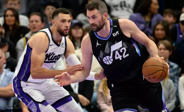 Utah Jazz forward Kevin Love, right, drives to the basket while guarded by Sacramento Kings guard Zach LaVine, left, during the first half of an NBA Cup basketball game Friday, Nov. 28, 2025, in Salt Lake City. (AP Photo/Tyler Tate)