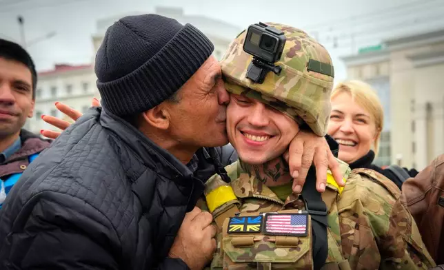 FILE - In this photo taken Sunday, Nov. 13, 2022, a Kherson resident kisses a Ukrainian soldier as Ukrainian army liberated the city from the Russian troops in Kherson, Ukraine, Nov. 13, 2022. (AP Photo/Efrem Lukatsky, file)