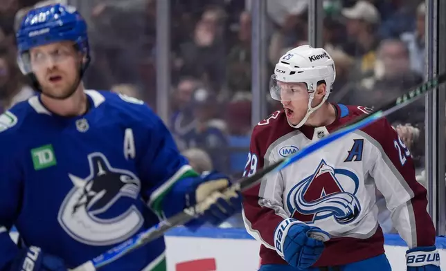 Colorado Avalanche's Nathan MacKinnon, back right, celebrates his first goal as Vancouver Canucks' Elias Pettersson skates past during the first period of an NHL hockey game in Vancouver, B.C., Sunday, Nov. 9, 2025.(Darryl Dyck/The Canadian Press via AP)