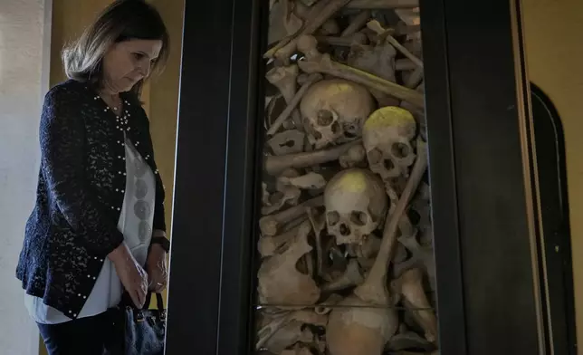 A Lebanese woman of Armenian descent prays by human remains of people killed by Ottoman Turks around the time of World War I in 1915, inside the Armenian Patriarchate in Antelias, north of Beirut, Lebanon, Sunday, Nov. 23, 2025. (AP Photo/Bilal Hussein)