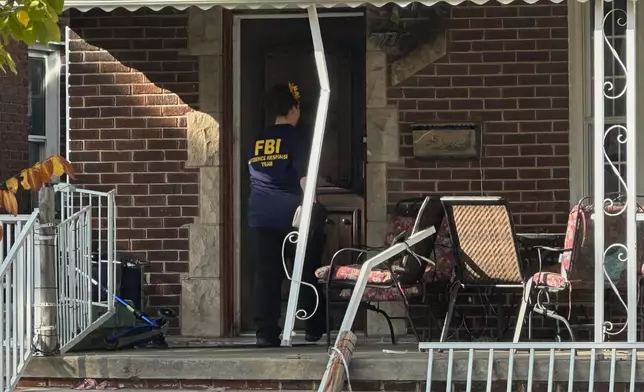 An FBI agent enters a home in a Dearborn, Mich., neighborhood on Friday, Oct. 31, 2025. (AP Photo/Mike Householder)
