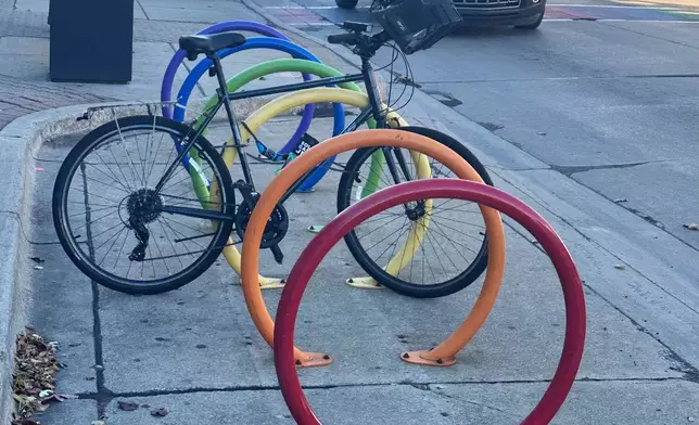 A bicycle is parked at a rainbow-themed bike rack along Nine Mile Road in Ferndale, Mich., Monday, Nov. 3, 2025. (AP Photo/Corey Williams)