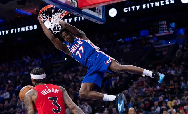 Philadelphia 76ers' VJ Edgecombe, top, dunks the ball with Toronto Raptors' Brandon Ingram, bottom, defending during the first half of an NBA basketball game, Wednesday, Nov. 19, 2025, in Philadelphia. (AP Photo/Chris Szagola)