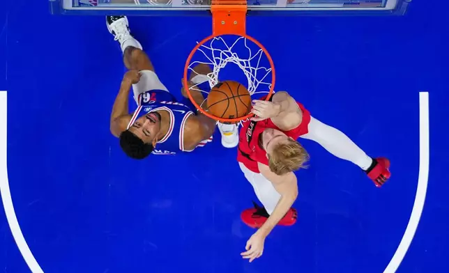 Toronto Raptors' Gradey Dick, right, dunks the ball with Philadelphia 76ers' Quentin Grimes, left, defending during the first half of an NBA basketball game, Wednesday, Nov. 19, 2025, in Philadelphia. (AP Photo/Chris Szagola)