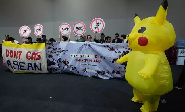 Activists, and one dressed in a Pikachu costume, protest Japan's financing of coal and natural gas projects during the COP30 U.N. Climate Summit, Friday, Nov. 14, 2025, in Belem, Brazil. (AP Photo/Fernando Llano)