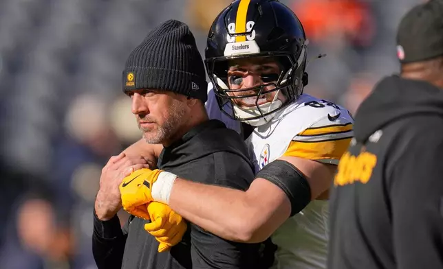 Pittsburgh Steelers quarterback Aaron Rodgers, left, gets a hug from Pat Freiermuth (88) before an NFL football game against the Chicago Bears, Sunday, Nov. 23, 2025, in Chicago. (AP Photo/Erin Hooley)